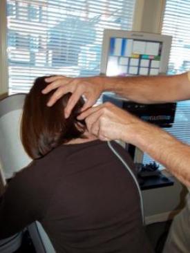 Woman getting Pro-Adjuster treatment for her neck pain.