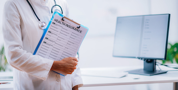 doctor holding folder with health insurance documents