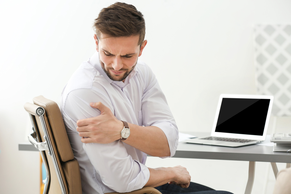 Man suffering from shoulder pain at work