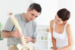 chiropractor showing a patient a spine in Monrovia, CA