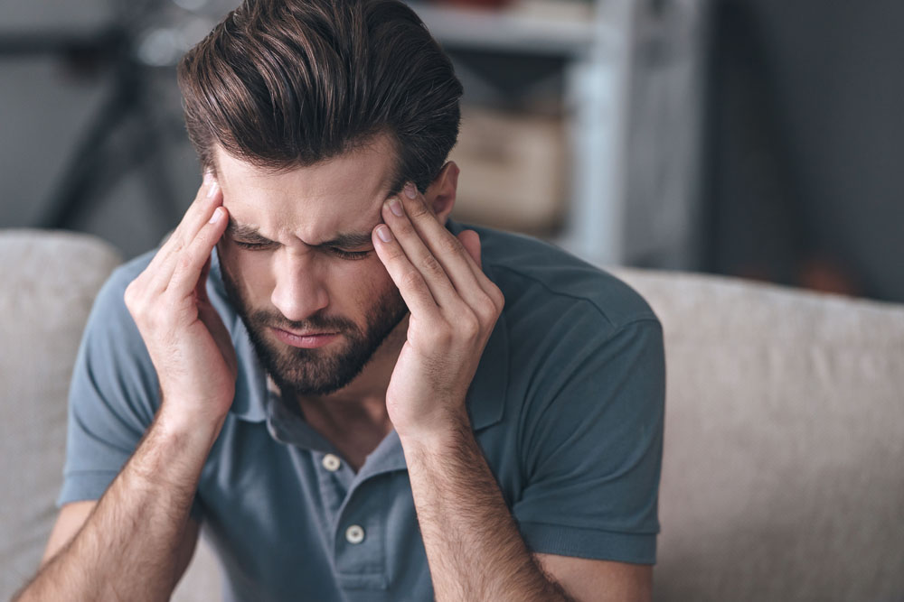 man suffering from a painful migraine