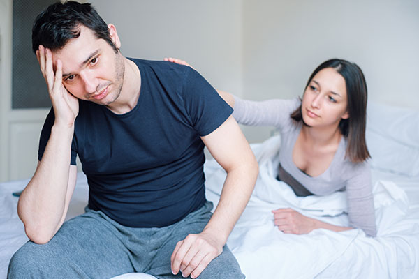 Male and female lying in the bed with sex problem - erectile dysfunction.