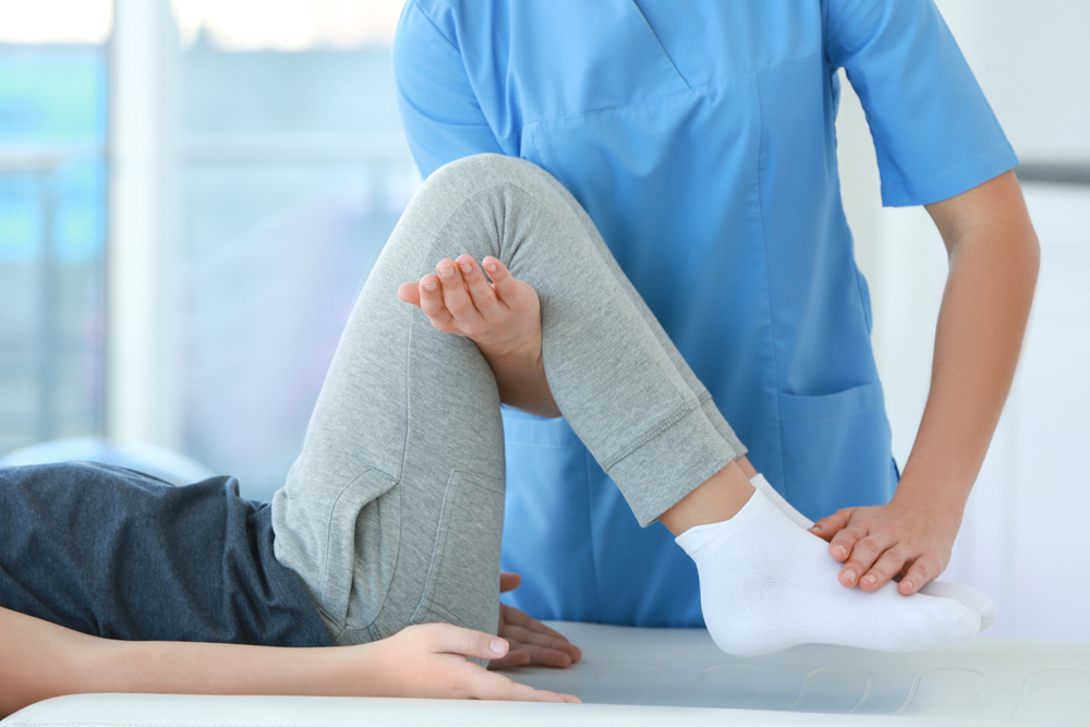 Chiropractor adjusting patients leg