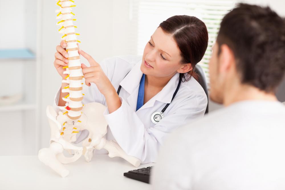 chiropractor showing patient model of the spine in Tacoma, WA