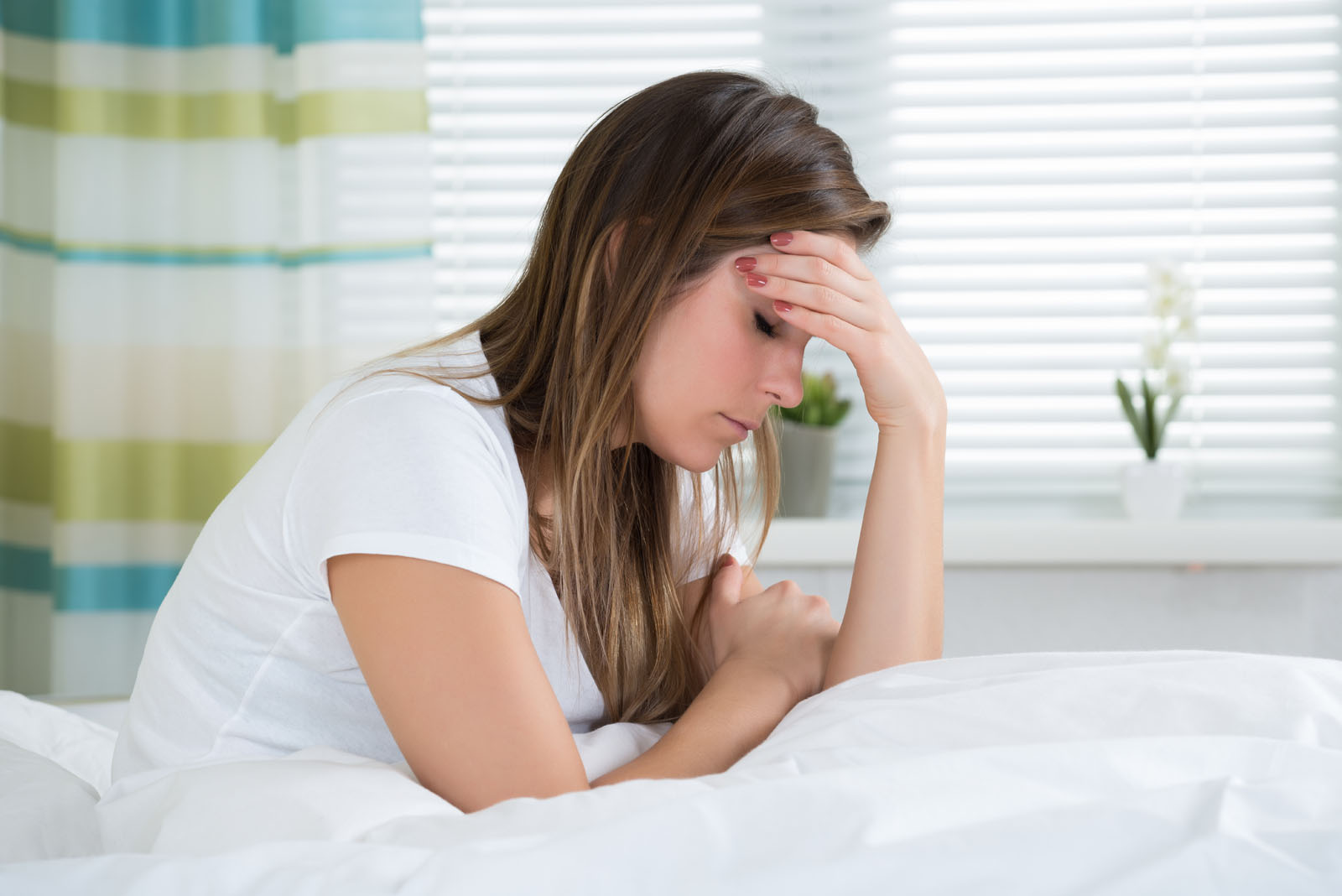 Woman waking up with a migraine