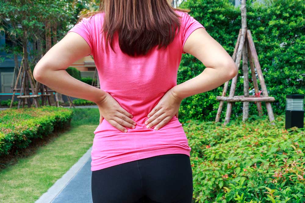 Woman with lower back pain needs chiropractic care in Louisville.
