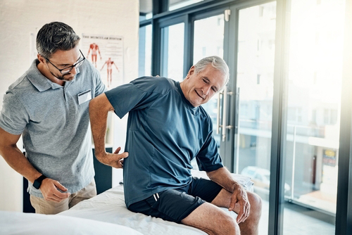 Chiropractor assessing client's back pain during chiropractic consultation