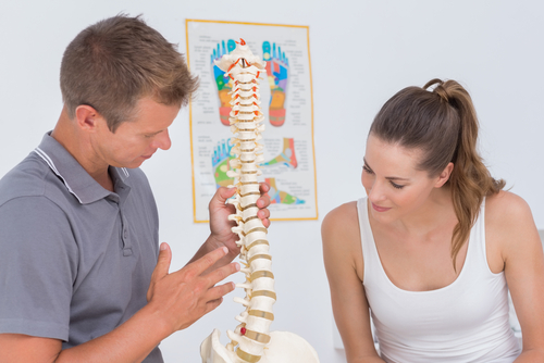 doctor showing spine model to a patient