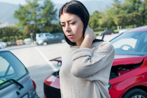 Woman experiencing neck pain from whiplash injury