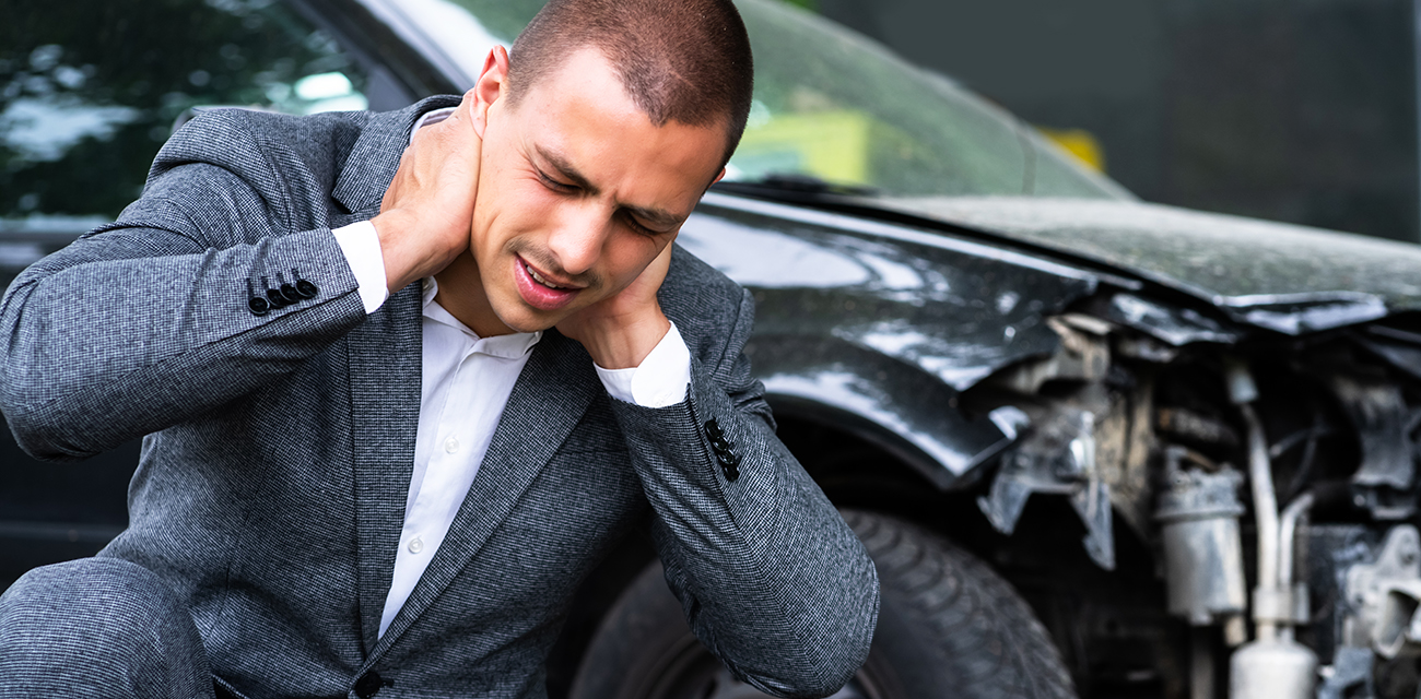 Man holding neck after car accident